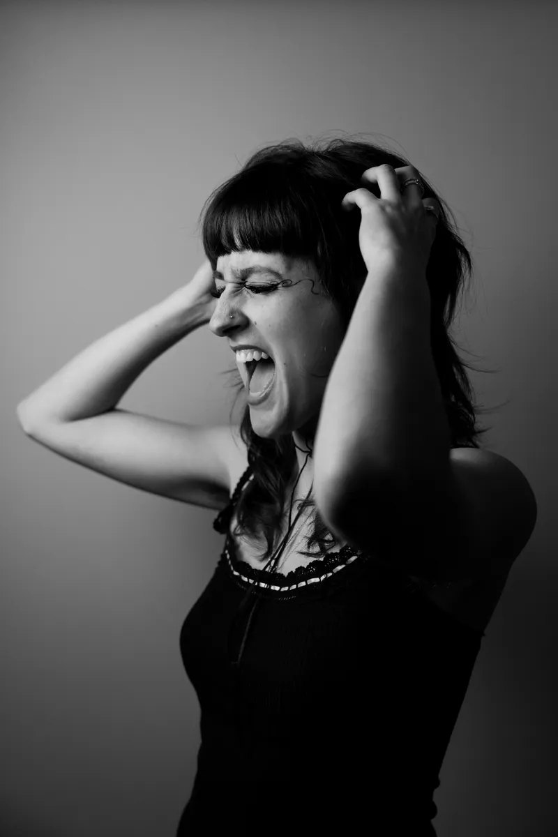 Black and white portrait, laughing with hands in hair
