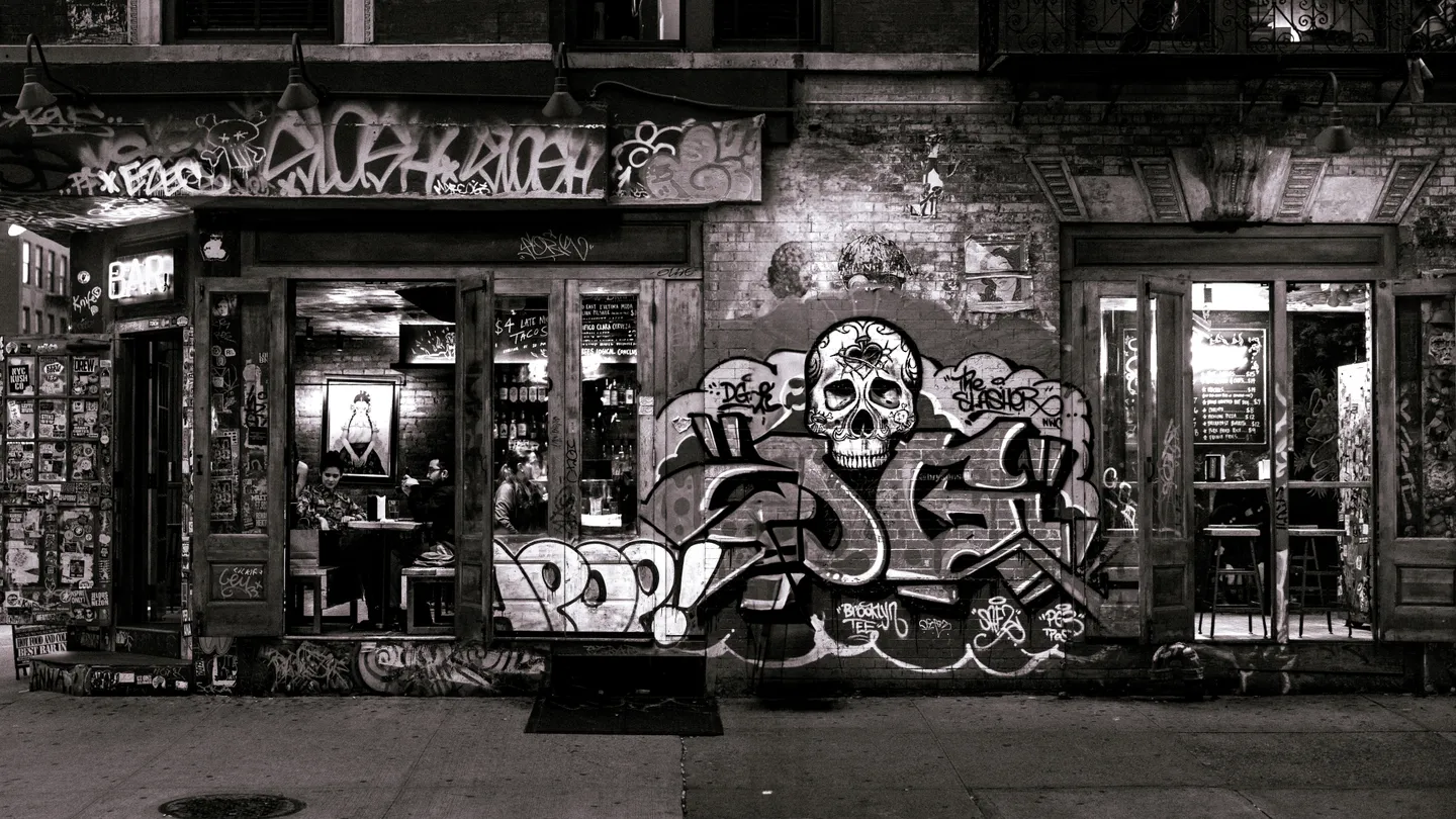 Black-and-white photograph of a graffiti-covered New York storefront