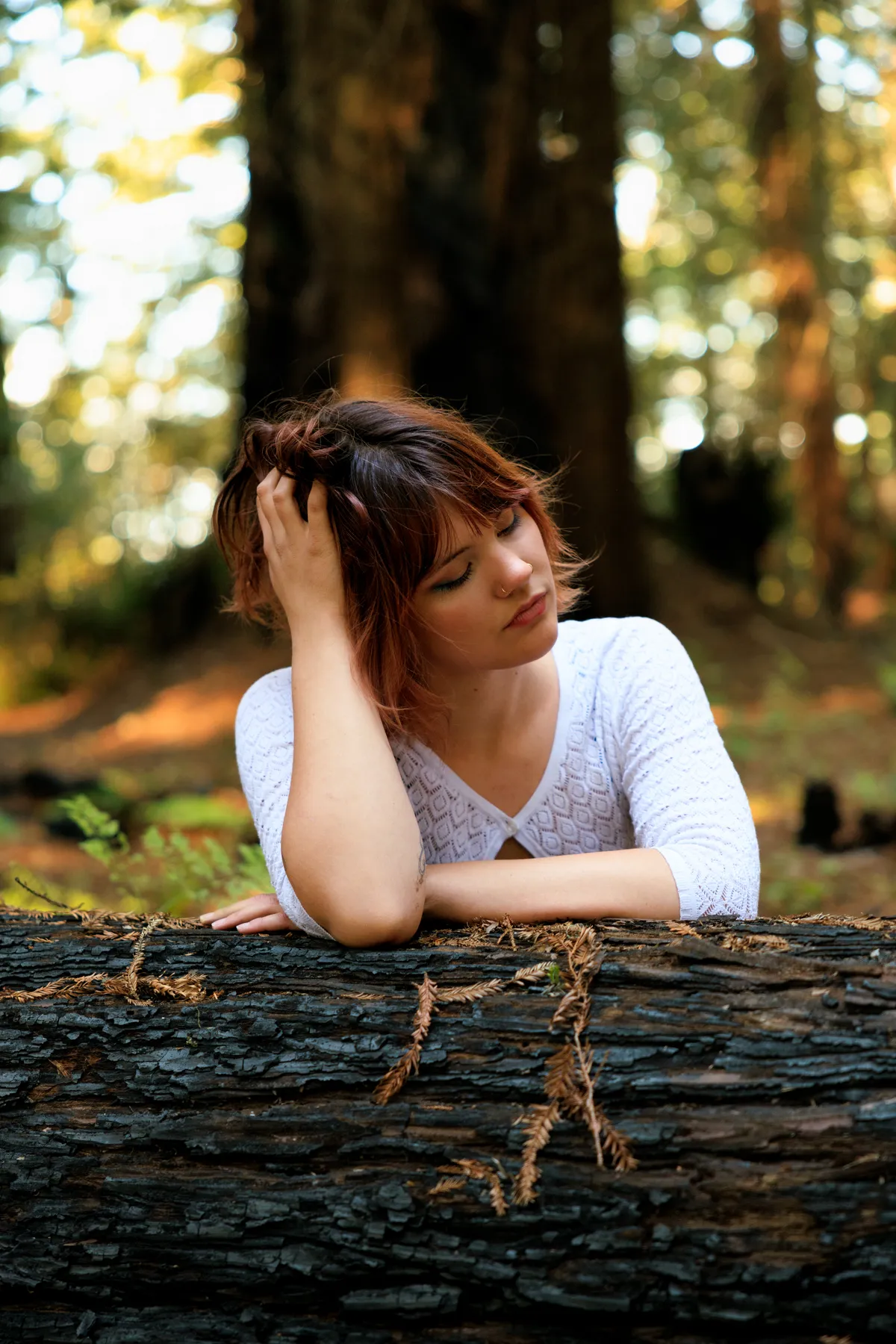 Gabi leaning on a redwood log